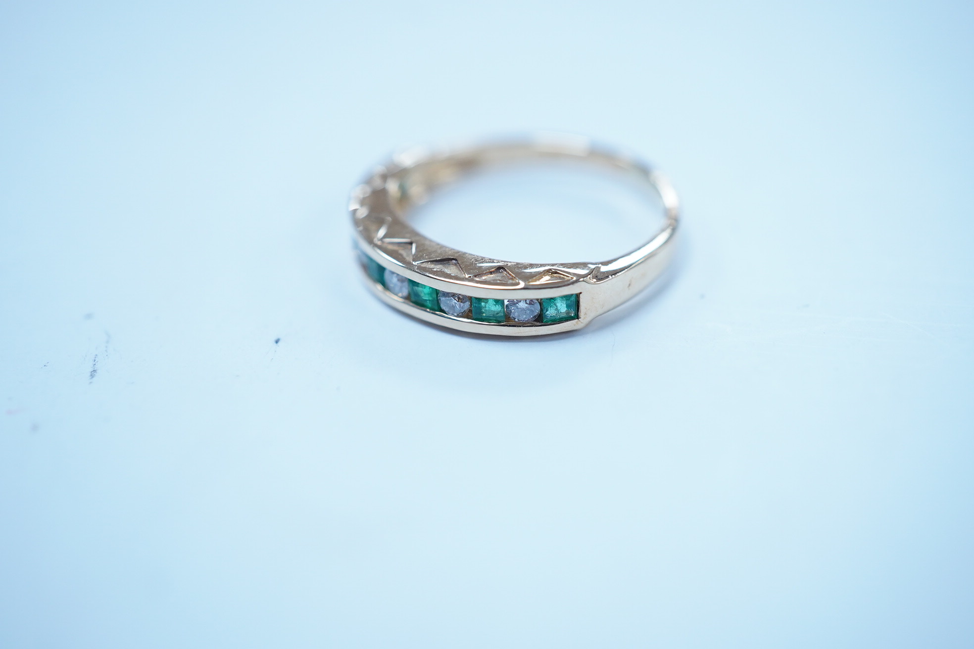 A modern 18k, seven stone emerald and six stone diamond set half hoop ring, size F/G, gross weight 2.4 grams. Condition - poor